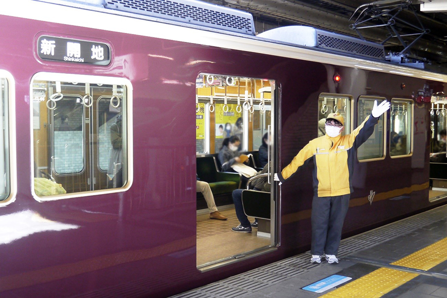 駅のホームで人が多い時に車両の扉をおさえてくれる黄色い服の人