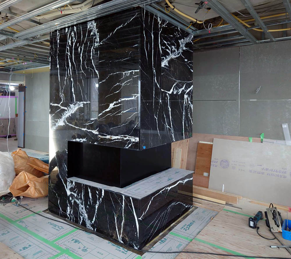 大理石張りの柱型とスチール製の飾り棚 | The Library