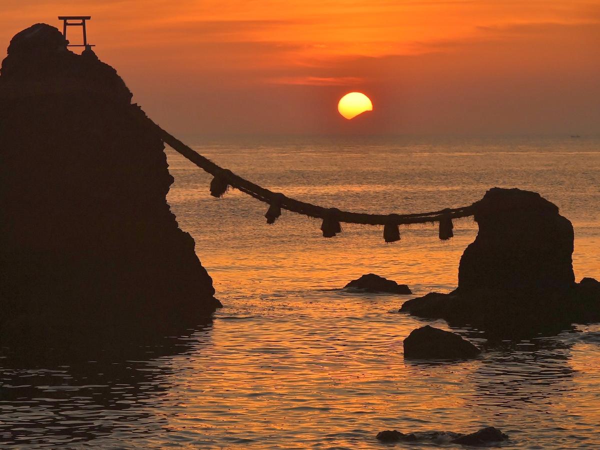 伊勢・二見興玉神社 梅雨の晴れ間に夫婦岩の間から富士山と朝日重なる