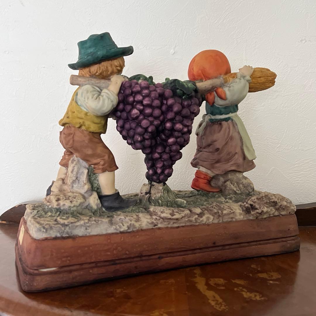 k196r124 Sculpture House ほうきでブドウを運ぶ少年と少女