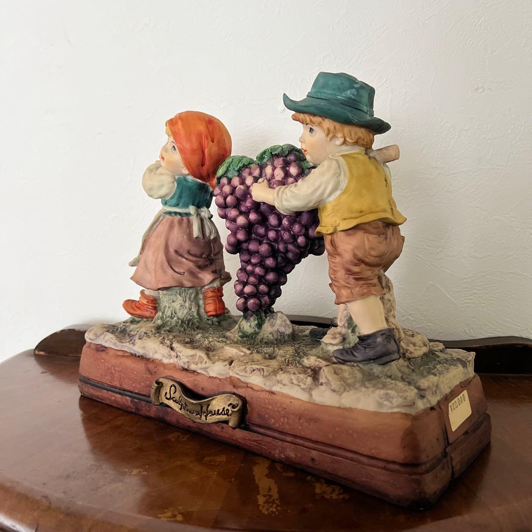 k196r124 Sculpture House ほうきでブドウを運ぶ少年と少女