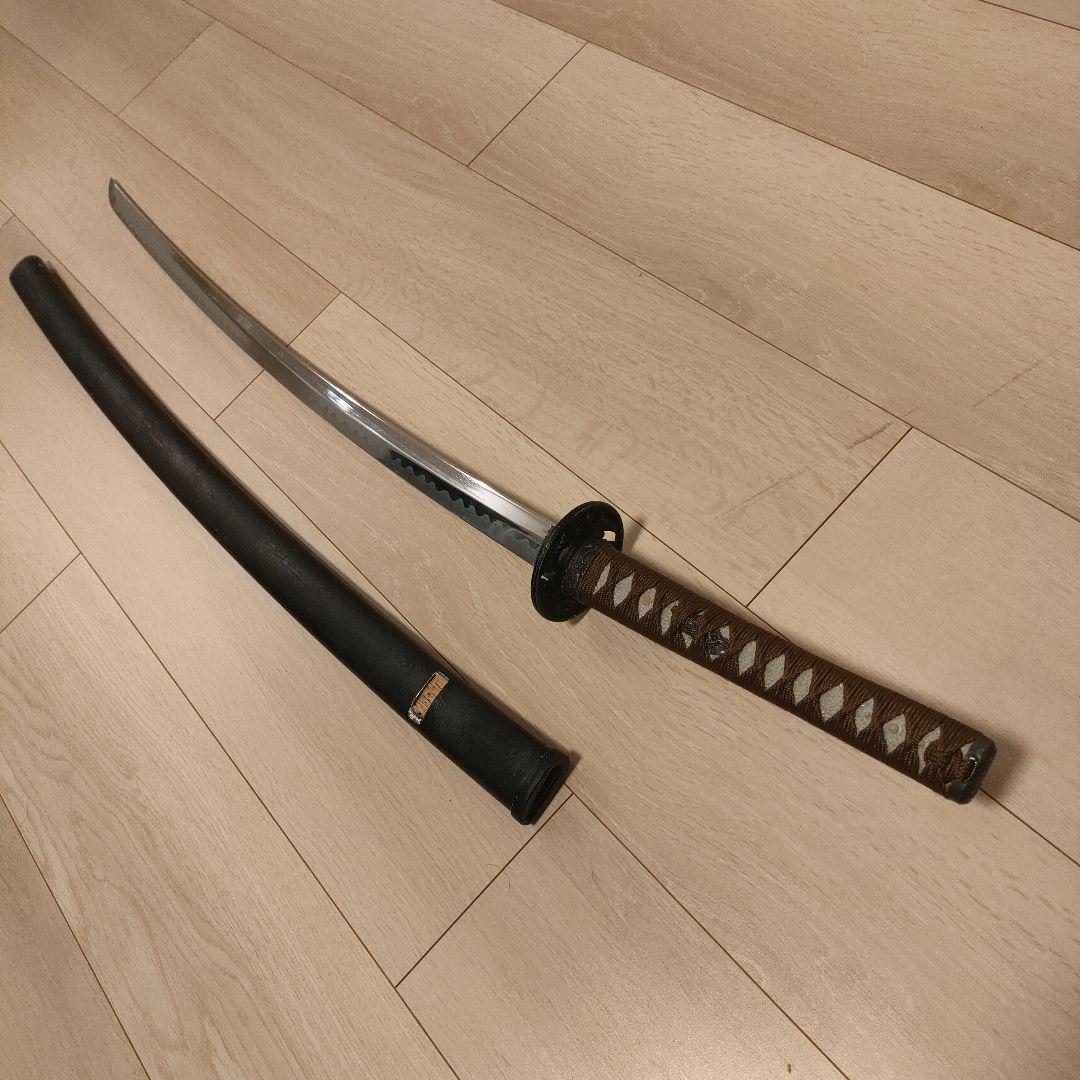 湾曲した刃の刀 黒い鞘と柄