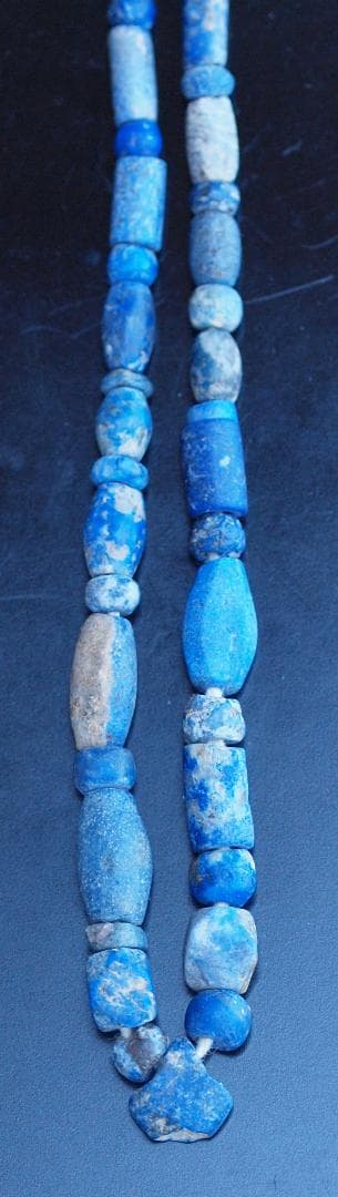 古代濃紺ラピスの管玉や丸玉をほぼ左右対称に編み、トップに斧型や多面体、80個の連