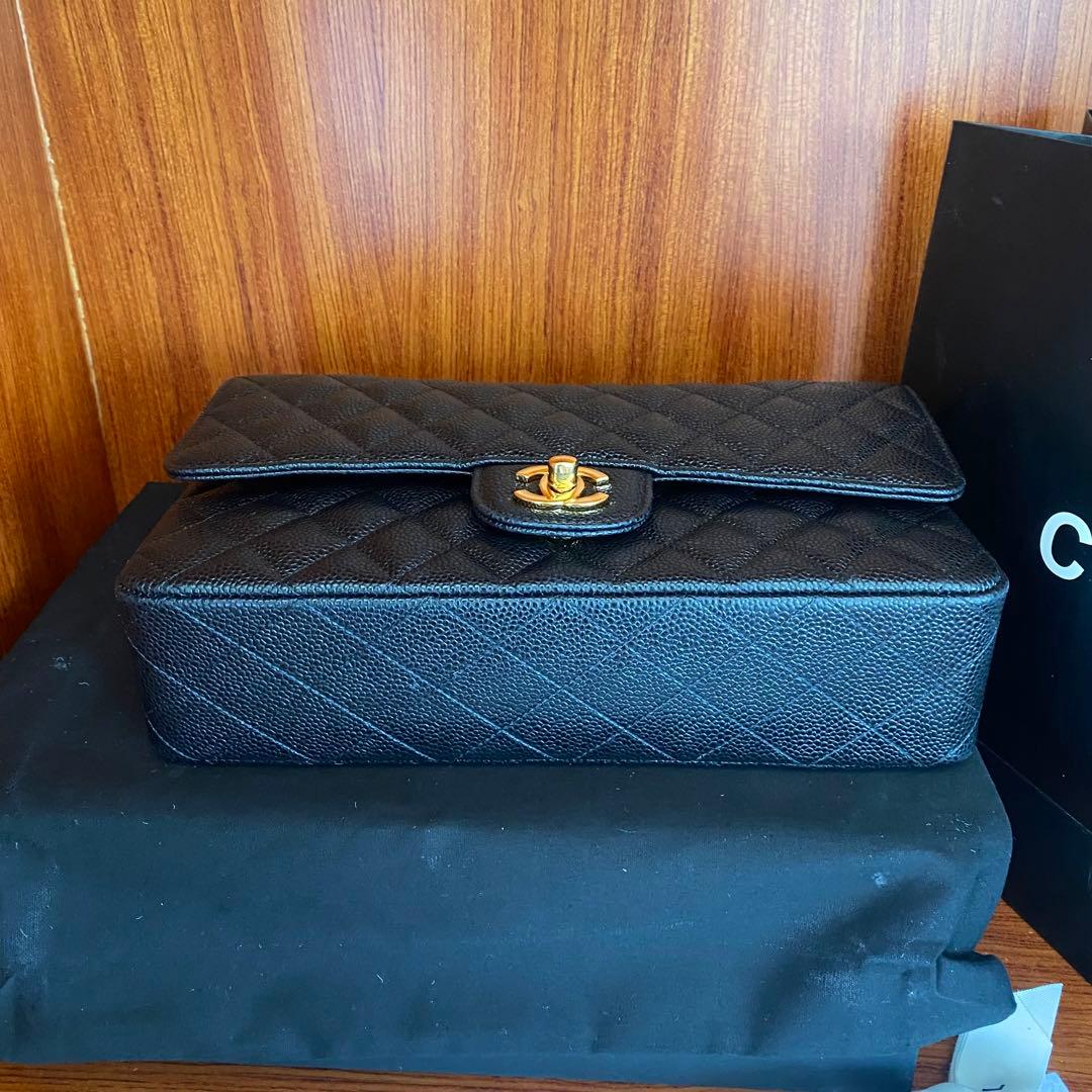 ブラックレザーのキルティングデザイン、ゴールドチェーン付きのショルダーバッグ。