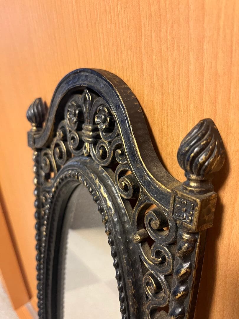 装飾的なオーバル型壁掛け鏡 黒と金のフレーム