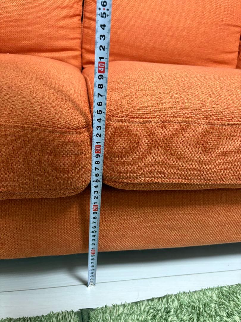 オレンジ色の3人掛けソファ